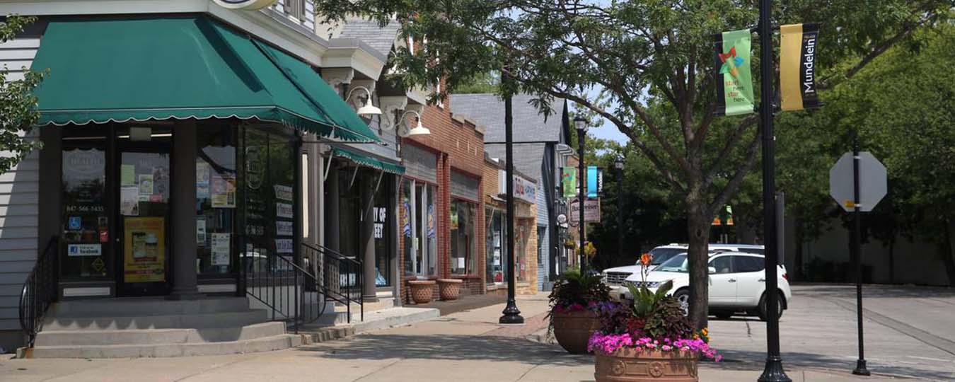 Downtown Mundelein sidewalk with shops and Mundelein banners